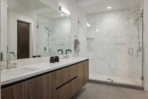 Bathroom featuring tile patterned flooring, vanity, and walk in shower