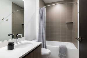 Full bathroom with shower / bath combination with curtain, vanity, and toilet