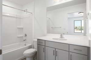 Full bathroom featuring vanity, shower / bath combination, and toilet