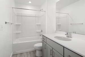 Full bathroom featuring shower / washtub combination, hardwood / wood-style floors, vanity, and toilet