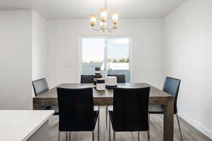 Dining area featuring hardwood / wood-style floors and an inviting chandelier