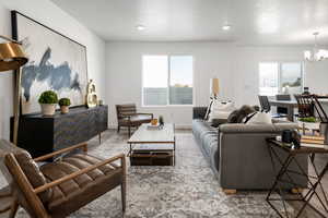 Living room with a textured ceiling, hardwood / wood-style flooring, and a notable chandelier