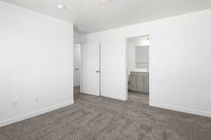 Unfurnished bedroom with carpet flooring and ensuite bath