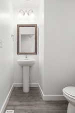 Bathroom featuring wood-type flooring and toilet