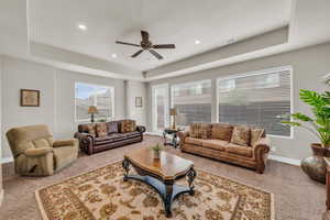 Living room featuring a raised ceiling and a wealth of natural light