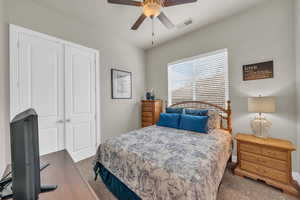 Bedroom featuring ceiling fan, a closet, and dark carpet