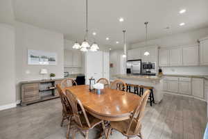 Dining area with light hardwood / wood-style floors and an inviting chandelier