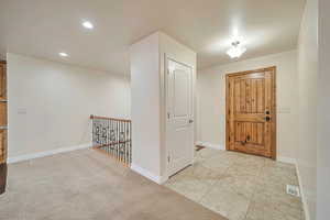 Foyer entrance featuring light colored carpet