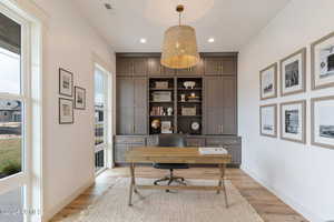 Office with light hardwood / wood-style flooring