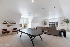 Recreation room featuring light carpet and lofted ceiling