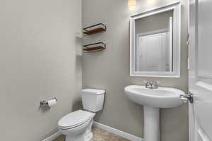 Bathroom featuring tile patterned flooring, toilet, and sink