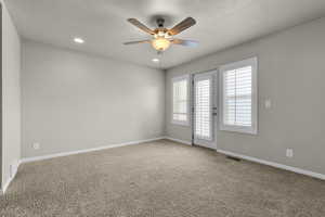 Spare room featuring ceiling fan, carpet, and a textured ceiling