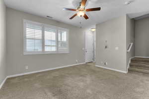 Spare room featuring light carpet and ceiling fan