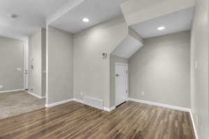 Empty room featuring dark wood-type flooring and a textured ceiling