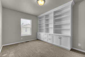 Carpeted empty room featuring a textured ceiling