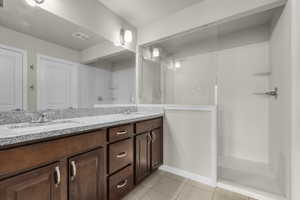 Bathroom featuring a shower, vanity, and tile patterned floors