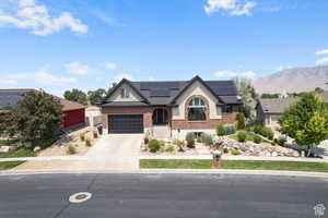 View of front facade featuring solar panels, a garage, and a mountain view