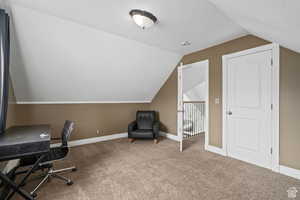 Home office with carpet, a textured ceiling, and vaulted ceiling