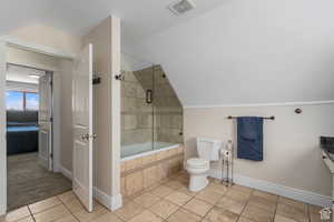 Bathroom featuring tile patterned flooring, enclosed tub / shower combo, vaulted ceiling, and toilet