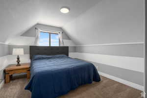 Bedroom with carpet, a textured ceiling, and lofted ceiling