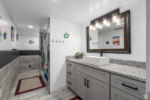 Bathroom with curtained shower and vanity