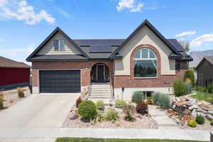 View of front of house with solar panels and a garage