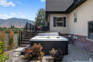 View of patio with a mountain view, cooling unit, and a hot tub