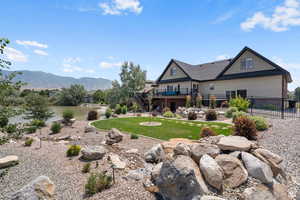 Back of house featuring a lawn and a deck with mountain view