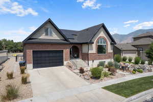 View of front of home featuring a mountain view, solar panels, and a garage