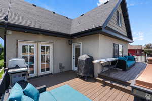 Wooden terrace featuring an outdoor hangout area and a grill