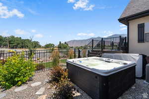 View of yard with a deck with mountain view and a hot tub