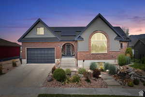 View of front facade with solar panels and a garage