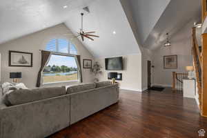 Living room featuring a textured ceiling, ceiling fan, dark wood-type flooring, and vaulted ceiling