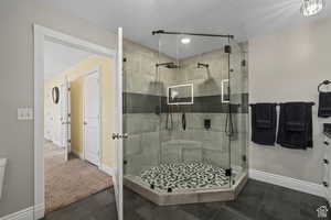 Bathroom featuring a textured ceiling, tile patterned flooring, an enclosed shower, and toilet