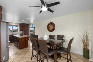 Dining area featuring light tile patterned floors, ceiling fan, and sink