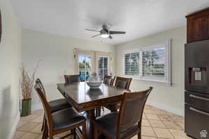 Dining room featuring ceiling fan, light tile patterned flooring, a textured ceiling, and french doors