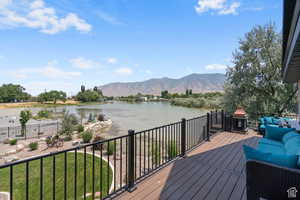 Deck featuring a lawn, outdoor lounge area, and a water and mountain view