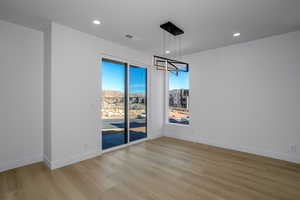 Unfurnished dining area with a chandelier and laminate flooring