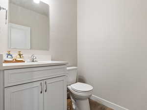 Bathroom with hardwood / wood-style flooring, vanity, and toilet