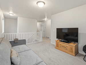 Living room with a textured ceiling and light colored carpet