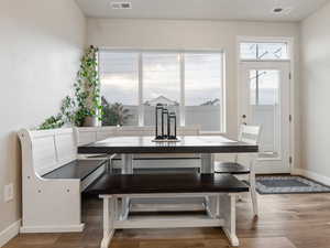 Dining space with dark hardwood / wood-style flooring