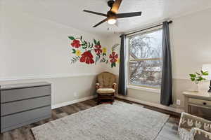 Sitting room with a textured ceiling, dark hardwood / wood-style flooring, and ceiling fan