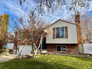 View of front of property featuring a garage and a front lawn