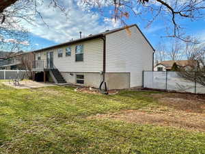 Rear view of house with a yard and a patio