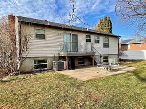 Back of property featuring central air condition unit, a patio area, and a yard