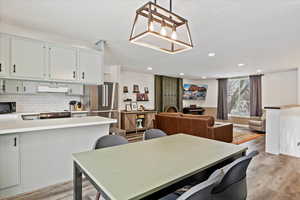 Dining area featuring a textured ceiling and light hardwood / wood-style floors