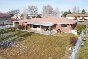 Rear view of property with a yard, a patio, and central AC unit