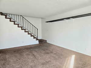 Spare room with carpet and a textured ceiling