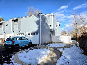 View of snowy exterior featuring a garage