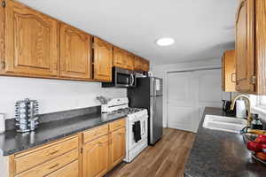 Kitchen with stainless steel appliances, dark wood-type flooring, and sink